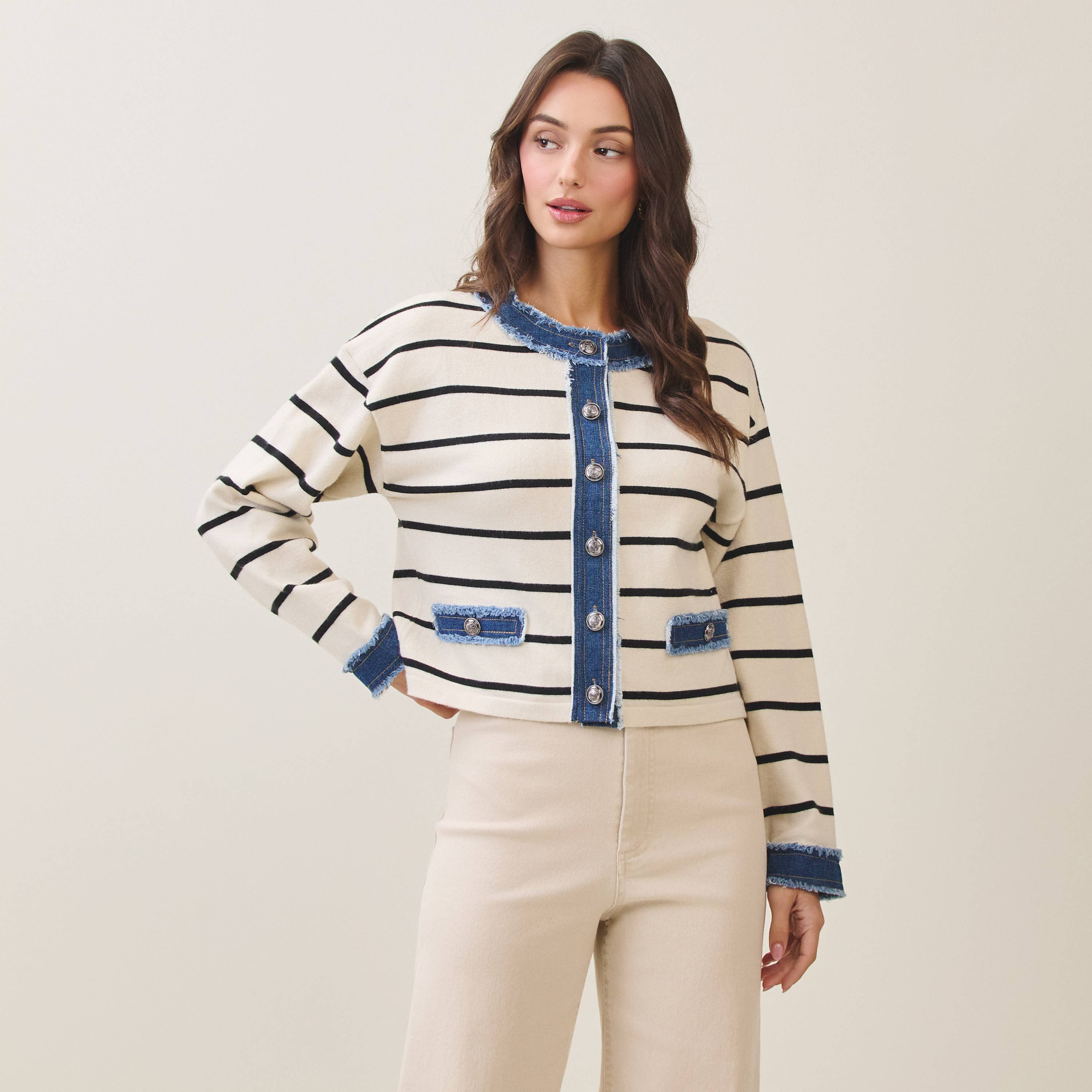 Woman wearing a striped cardigan sweater with denim accents