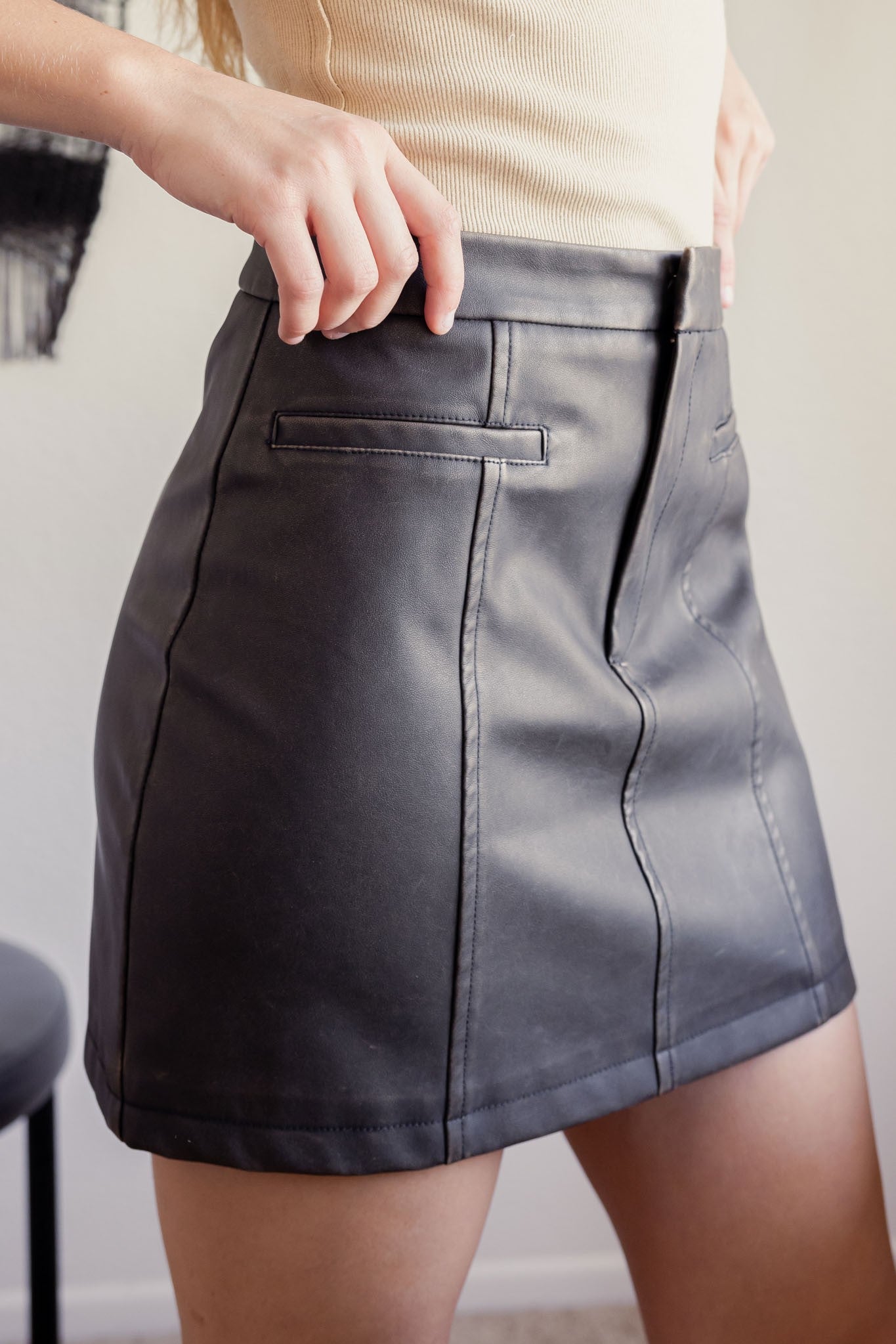 Side view of Washed Vegan Leather Skirt with panel detail and pockets