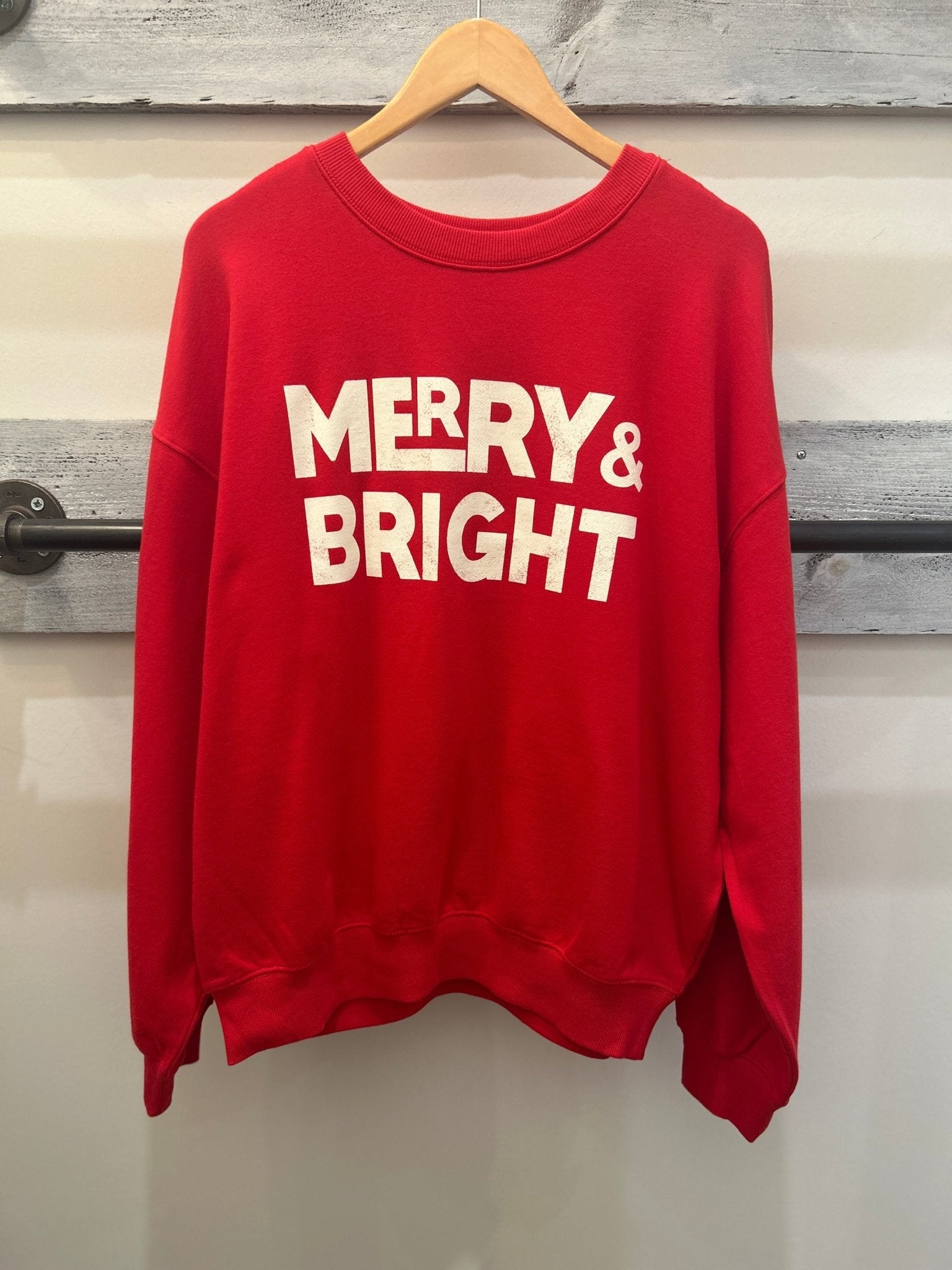 Red sweatshirt with off-white 'Merry & Bright' graphic for Christmas holiday.