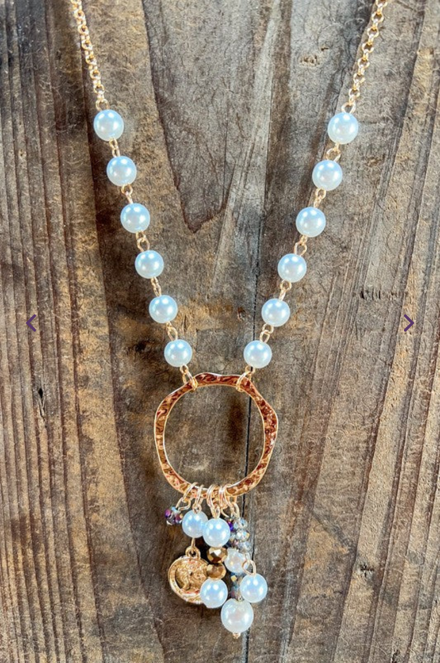 Necklace with circular pendant and beads on a wooden surface