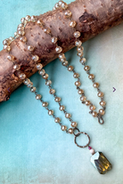 Necklace with beads and a pendant on a textured surface
