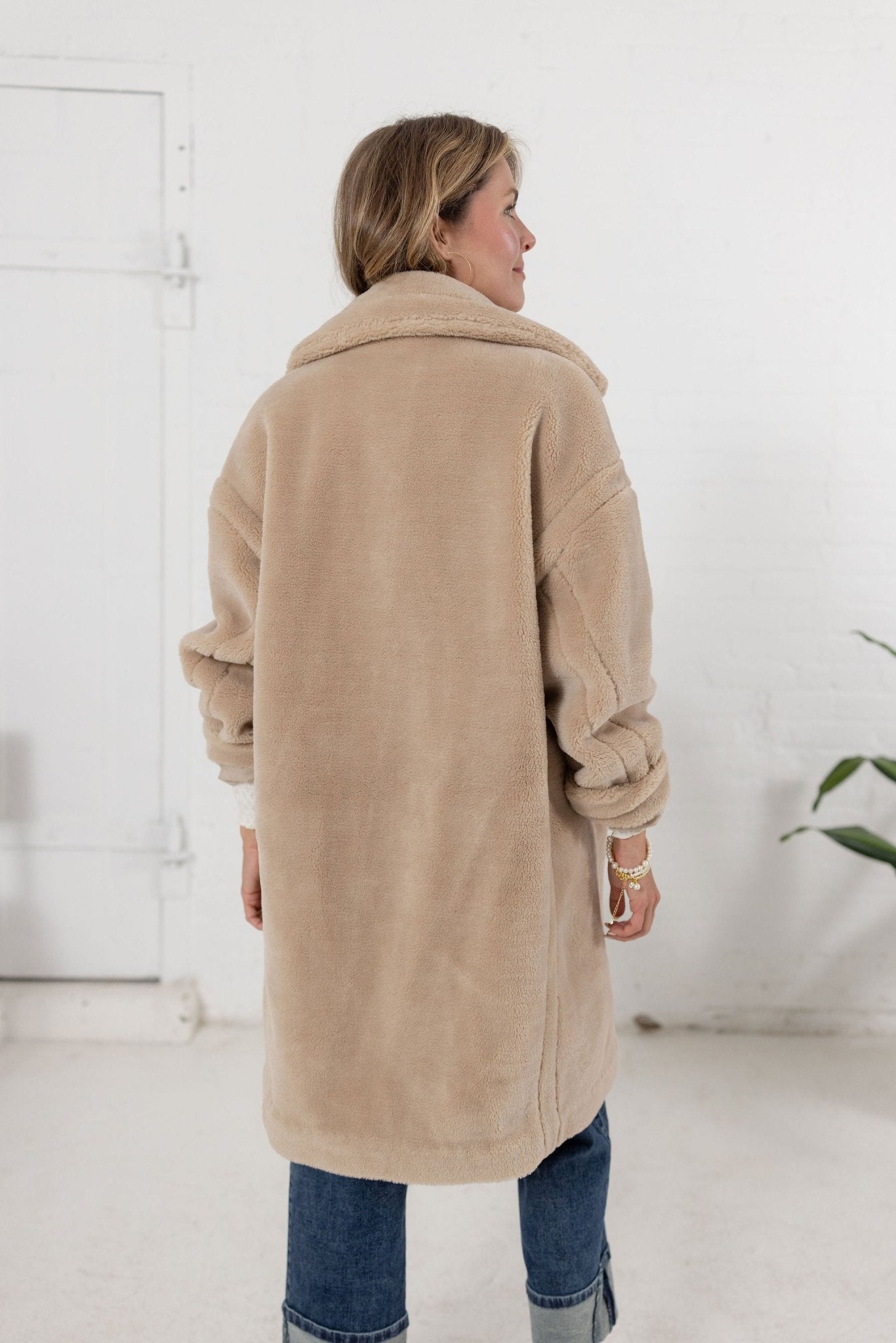 woman showing the back of the plush teddy coat from Mainstream Boutique Bloomington